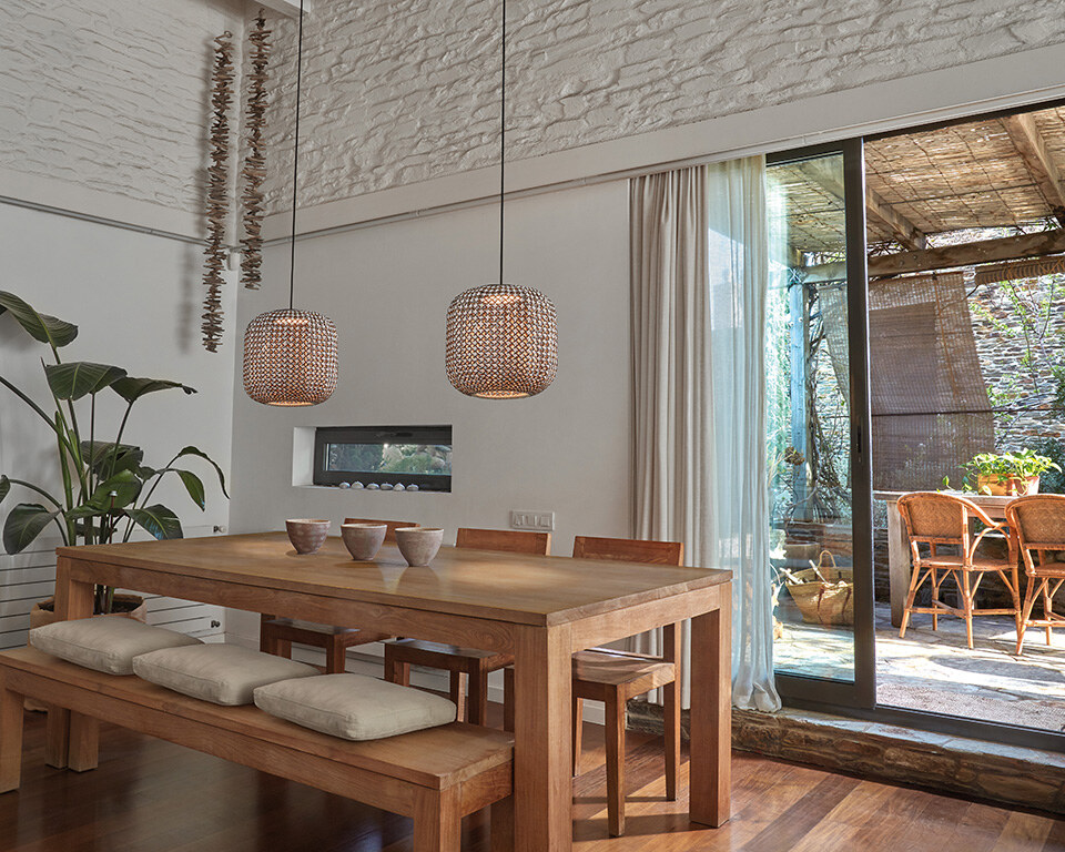 Eine zylindrische Hängeleuchte mit einem durchbrochenen, gemusterten Schirm, an einem schlanken Kabel befestigt.